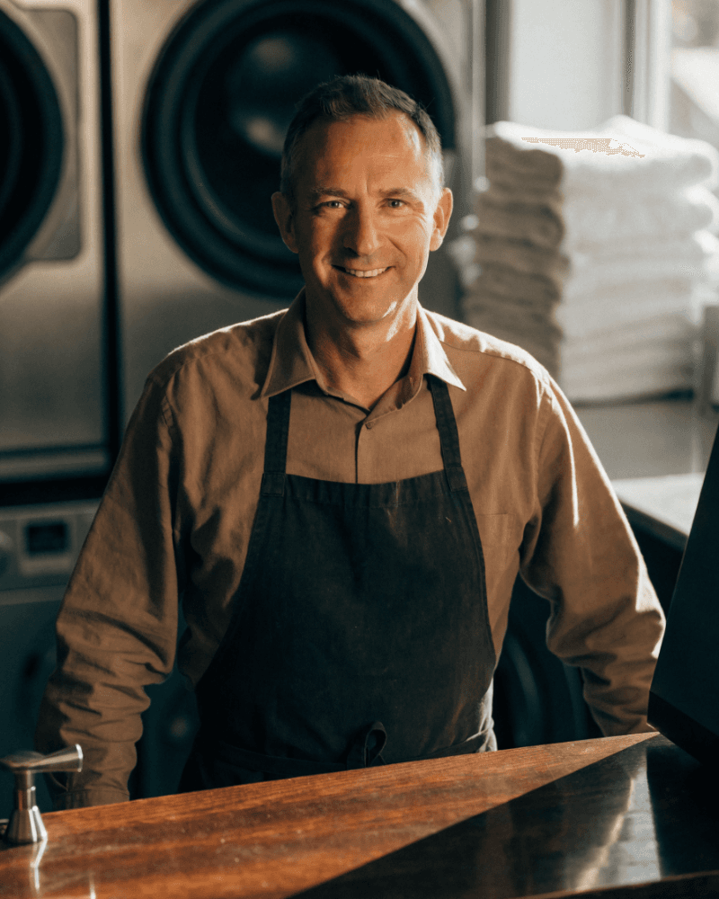 Portrait of a laundrette owner behind the counter